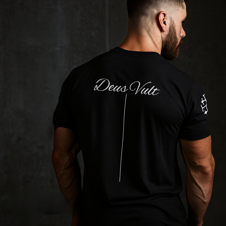 Rugged man in a black Deus Vult graphic tee, featuring historical warrior typography for modern resilience.